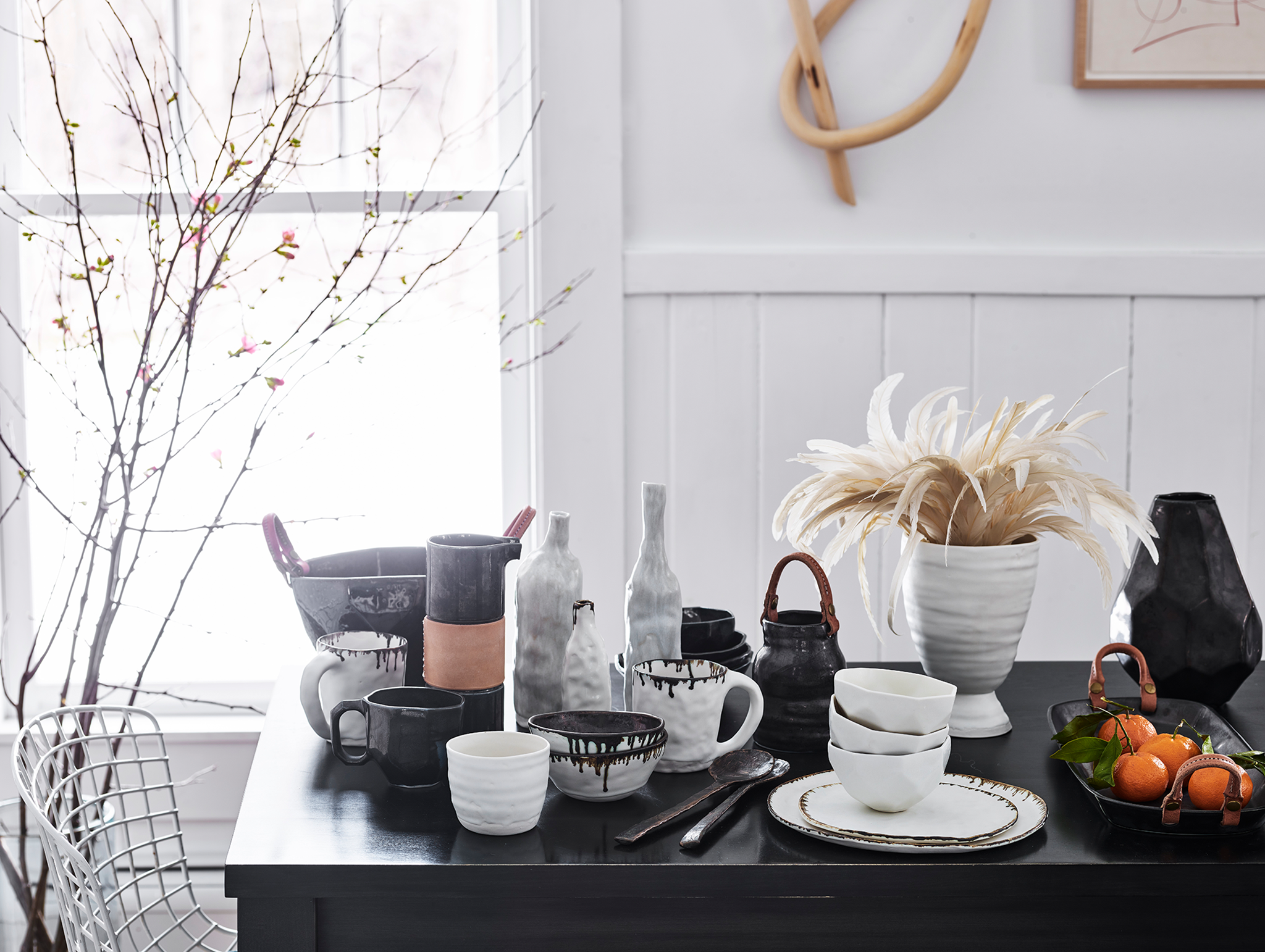 Winter table of black and white ceramic dinnerware and decor with leather and bronze accents