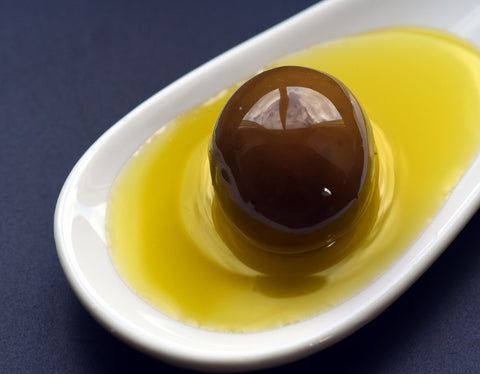 olive in a dish of olive oil for the topic "is olive oil acidic"