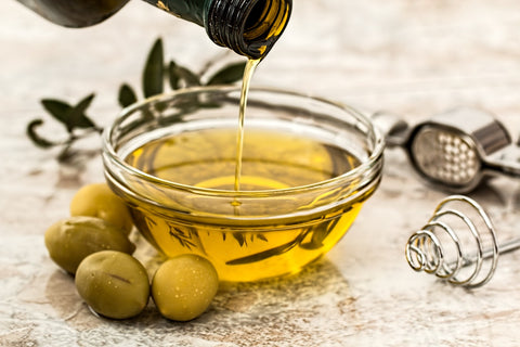 olive oil being poured into serving dish