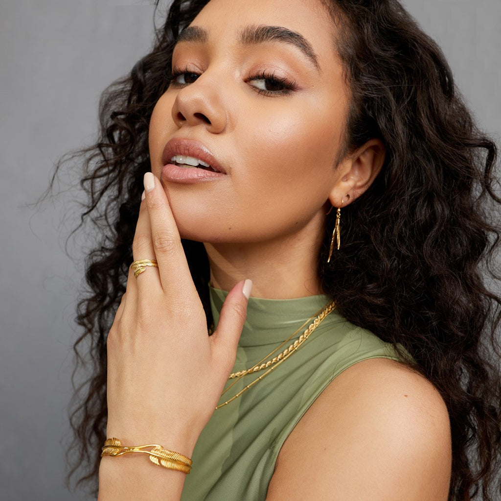 A woman wearing gold plated FIYAH jewellery