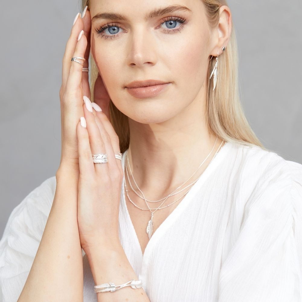 A woman wearing silver jewellery from the FIYAH Plume collection