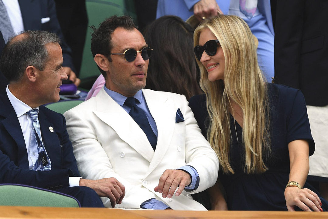 Actor Jude Law wearing white suit and round sunglasses at Wimbledon