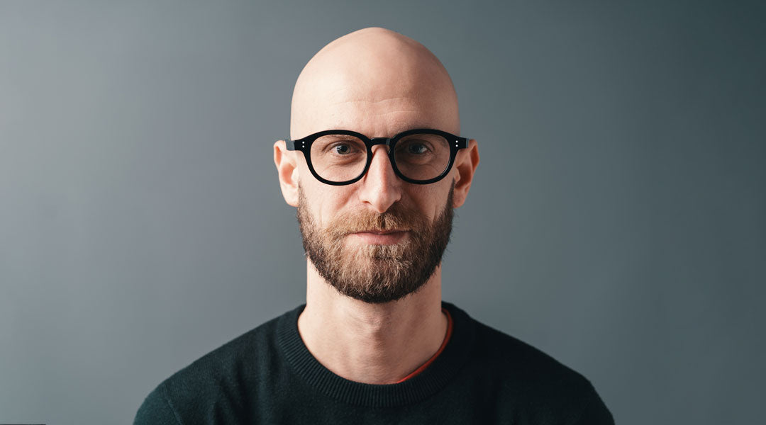 Bald man wearing black glasses frame