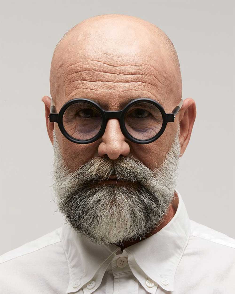 Bald man wearing round black glasses frame