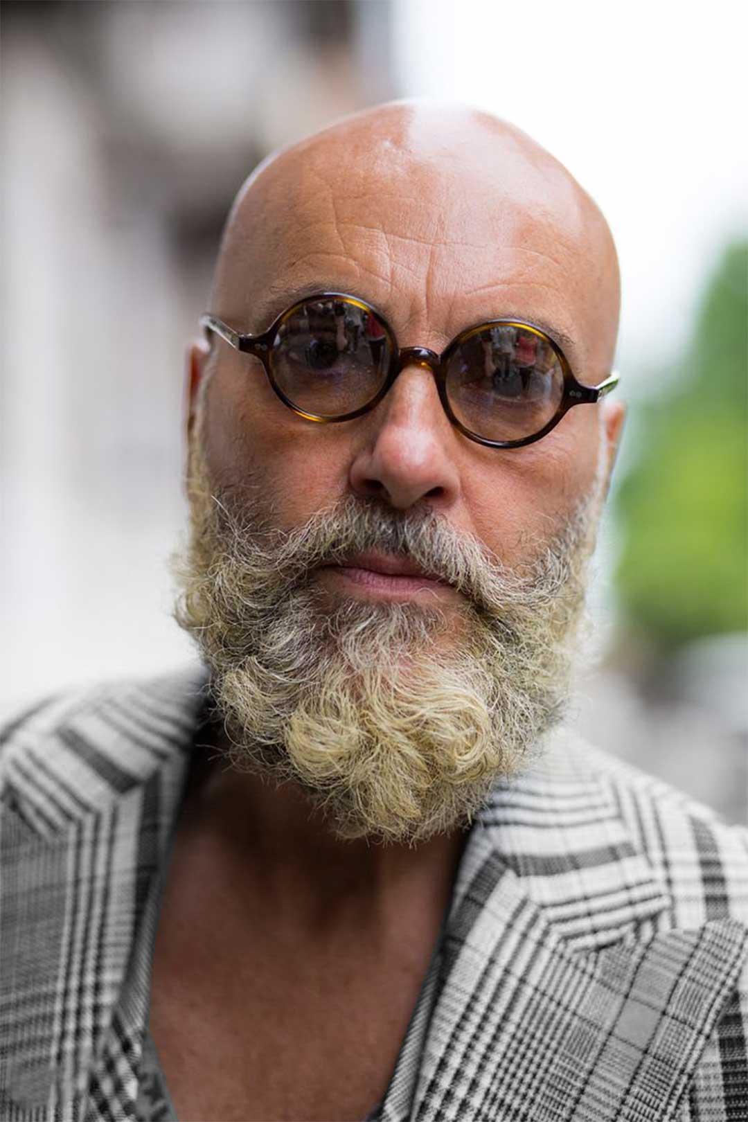 Bald man with beard wearing round tortoise shell glasses frame