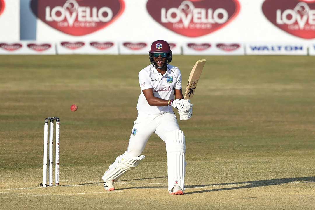 Batsman Kraigg Brathwaite wearing a batting helmet and sunglasses on cricket field on bright sunny day