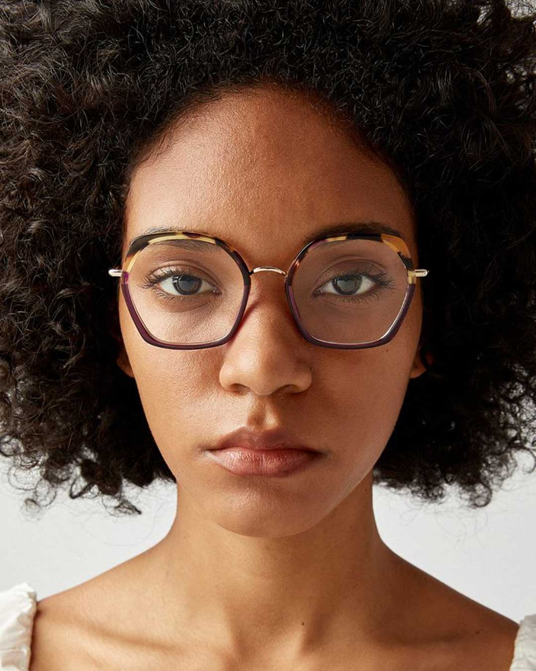 Black woman with afro hair wearing large geometric eyeglasses frame