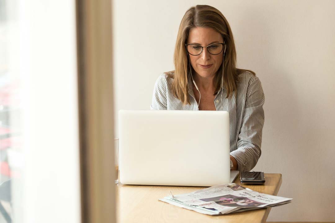 Blonde lady using laptop computer wearing cat eye glasses frame