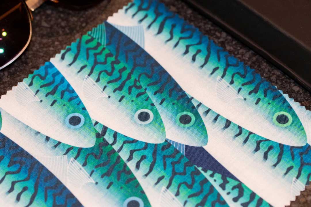 Blue and teal coloured fish pattern printed on eyeglass cleaning cloth