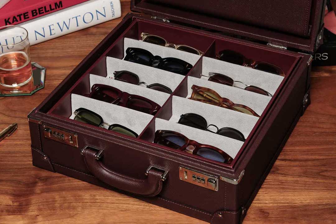 Burgundy leather sunglasses box containing multiple spectacle and sunglasses frames