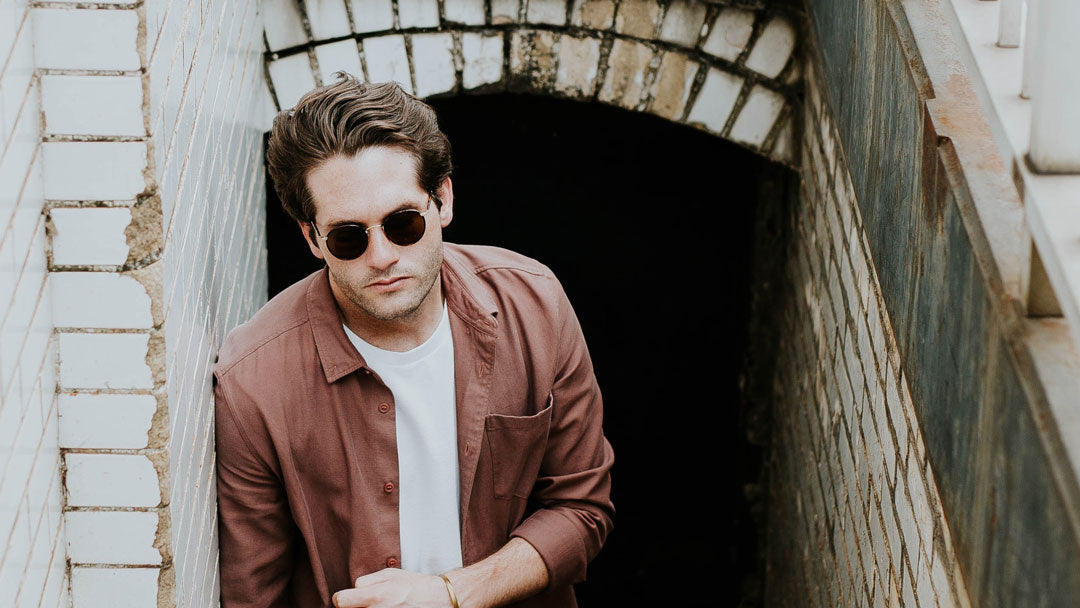 Caucasian male in large round sunglasses going up stairs