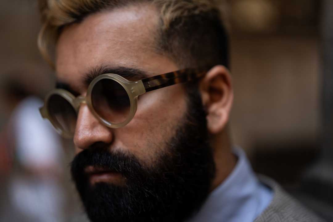 Close side view of bearded man wearing round sunglasses frame
