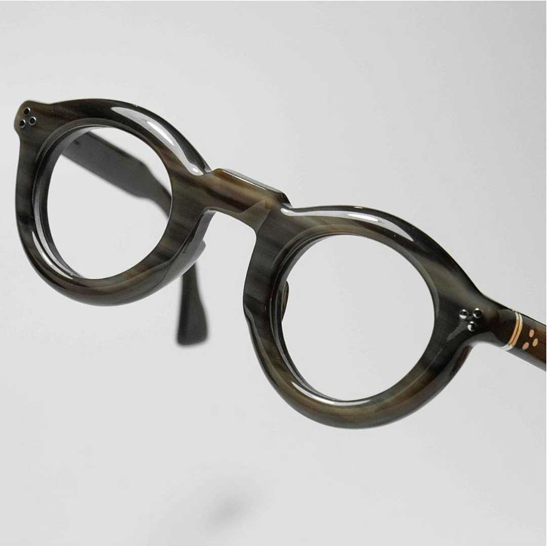 Close three quarter view of thick round horn spectacle frame