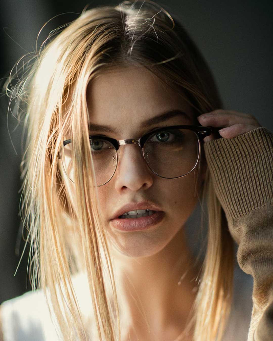 Close view of female wearing black and silver browline glasses frame