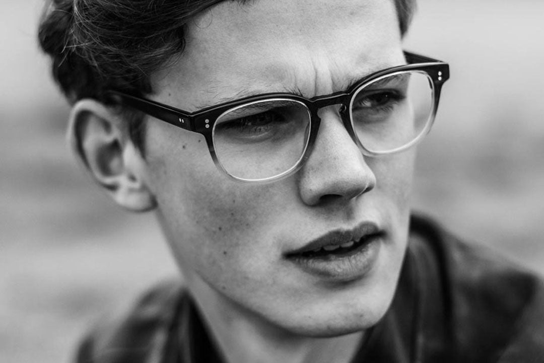 Close view of young man wearing Wayfarer style glasses frame