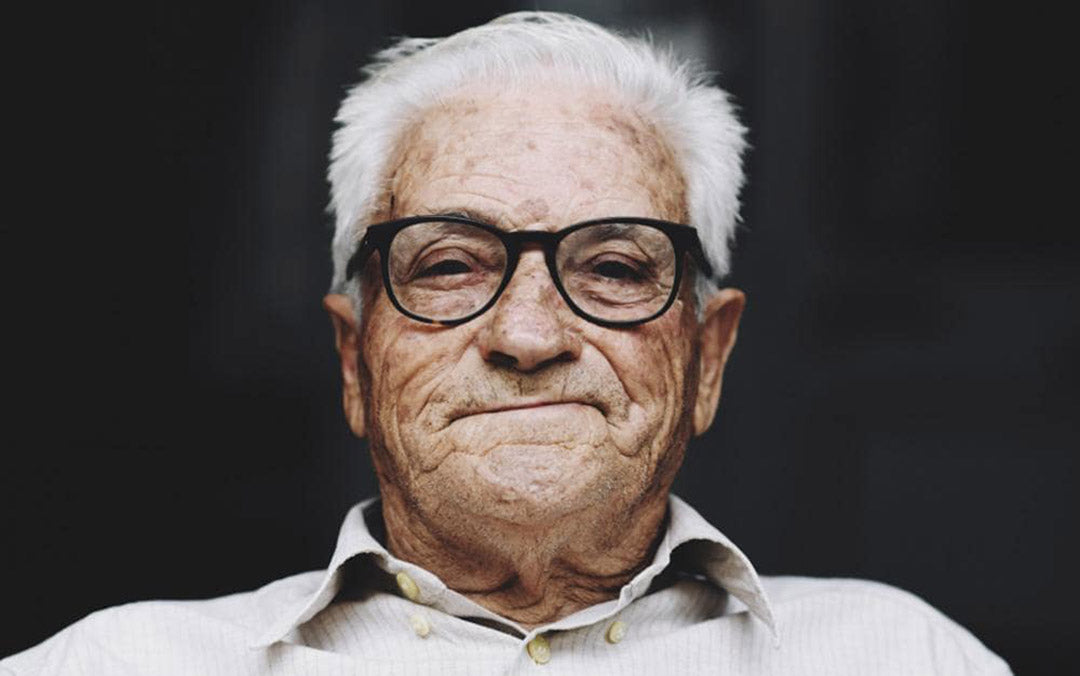 Disgruntled looking elderly man with short grey hair and rounded rectangular eyeglass frame