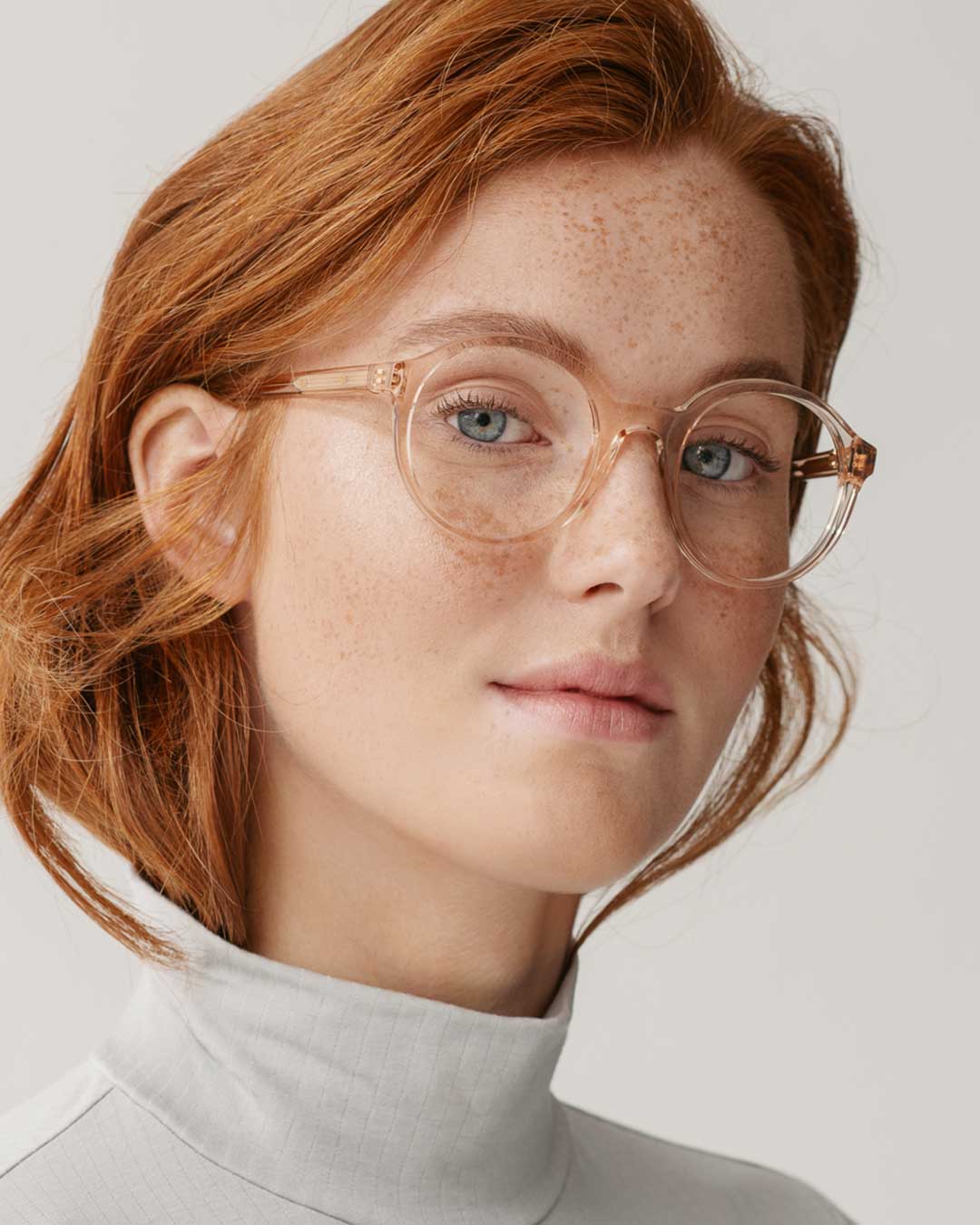 Ginger haired woman wearing round clear frame eyeglasses