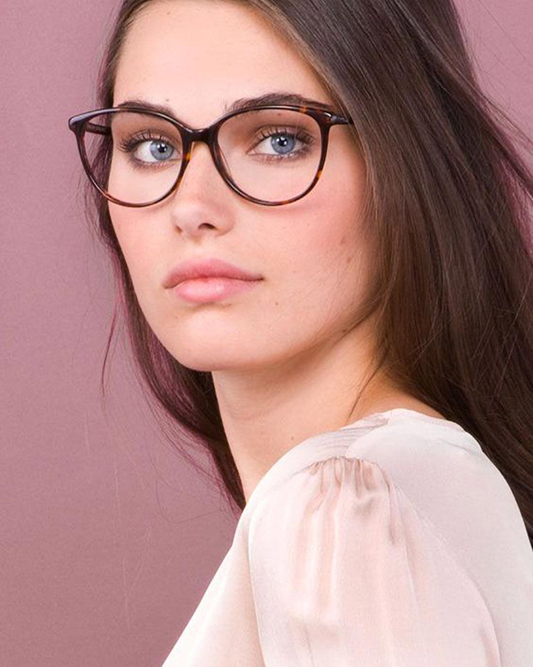 Girl with brown hair wearing cat eye glasses and white shirt