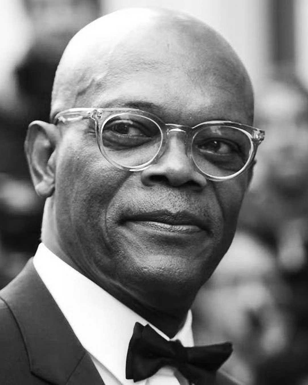 Greyscale portrait of Samuel L Jackson wearing bow tie and clear round spectacle frame