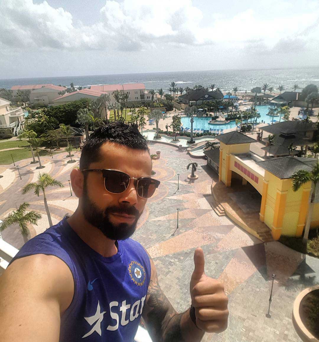 Indian cricket player Virat Kohli on hotel balcony wearing RayBan Clubmaster sunglasses frame