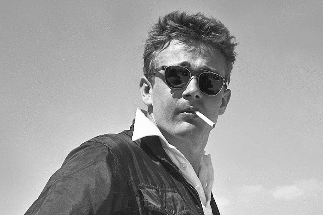 James Dean wearing flip up sunglasses frame with cigarette in is mouth