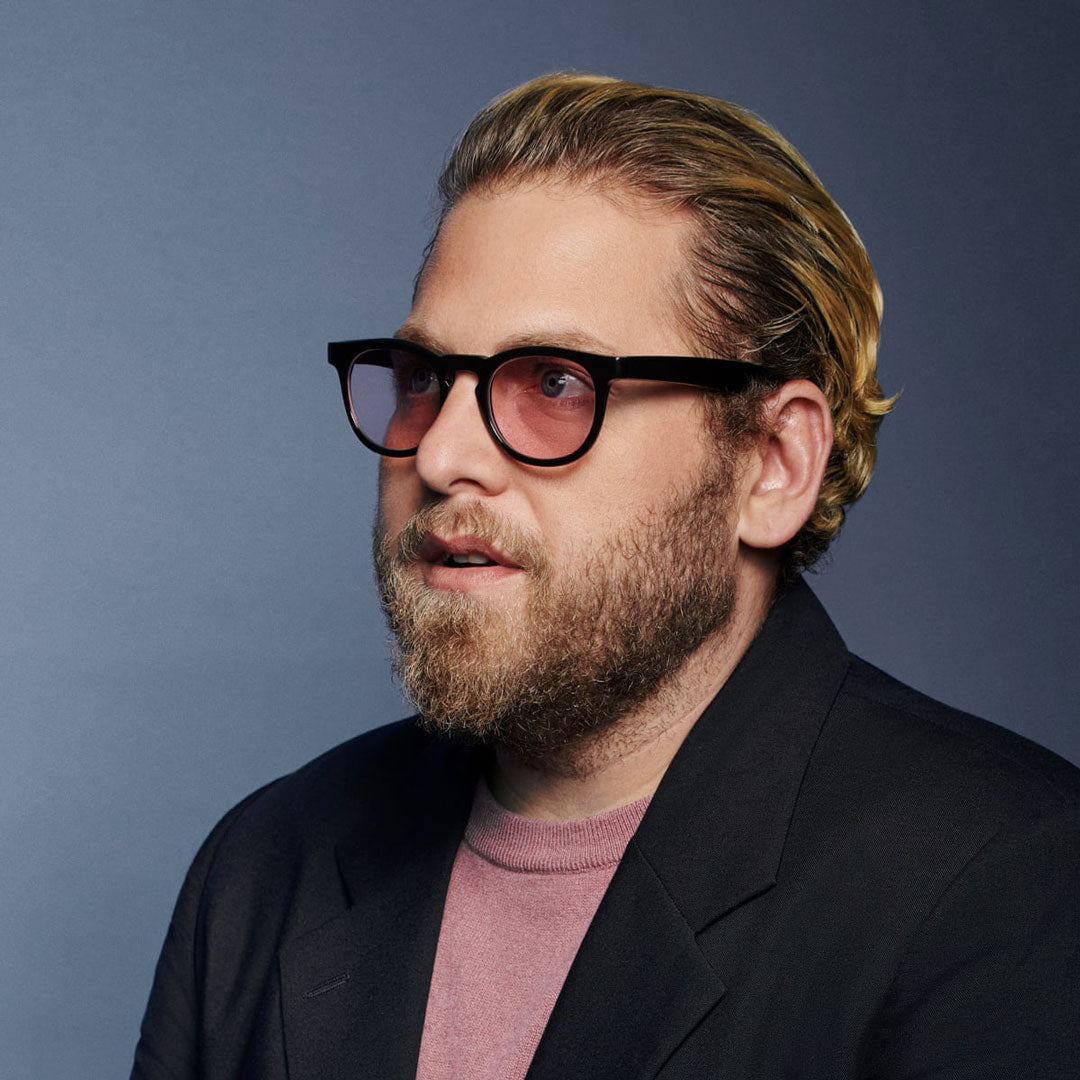 Jonah Hill wearing round black glasses with purple tinted lenses