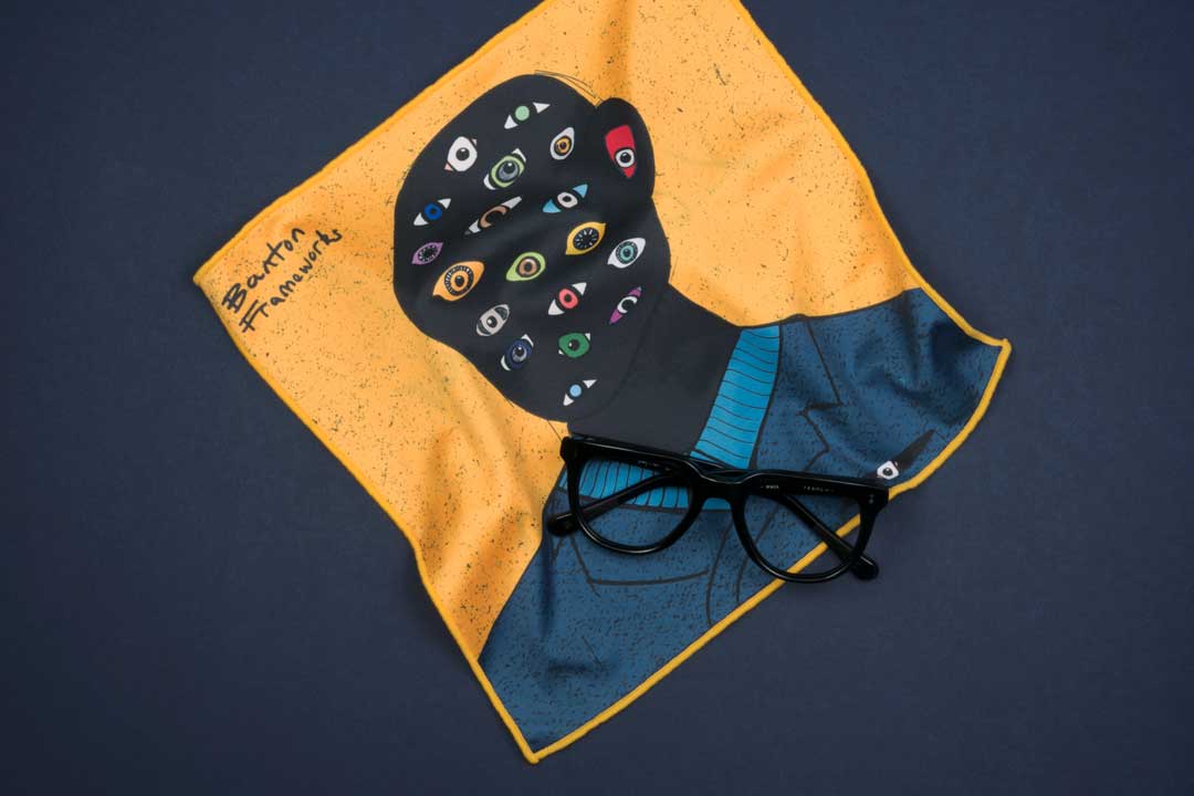 Large yellow glasses cleaning cloth on blue background with black spectacle frame on top