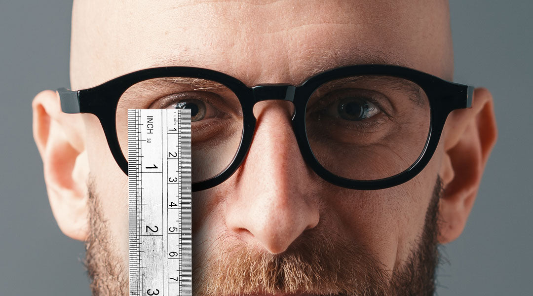 Man measuring his ocular height with a white ruler