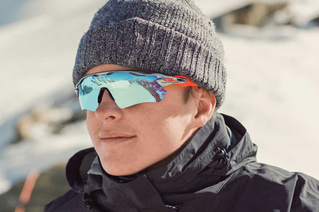 Man wearing hat and mirrored skiing sunglasses frame in mountains