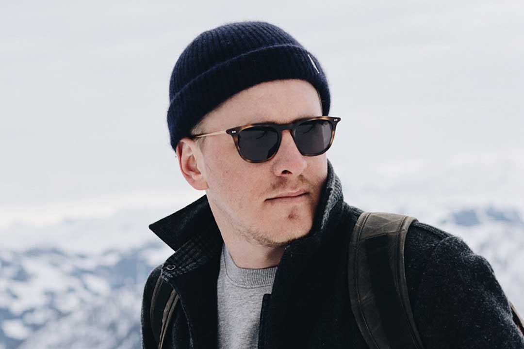 Man wearing hat jacket and tortoise sunglasses on cold winter day