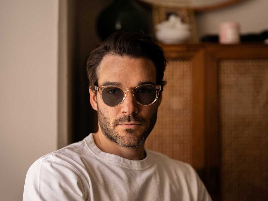 Man wearing round clear frame sunglasses frame