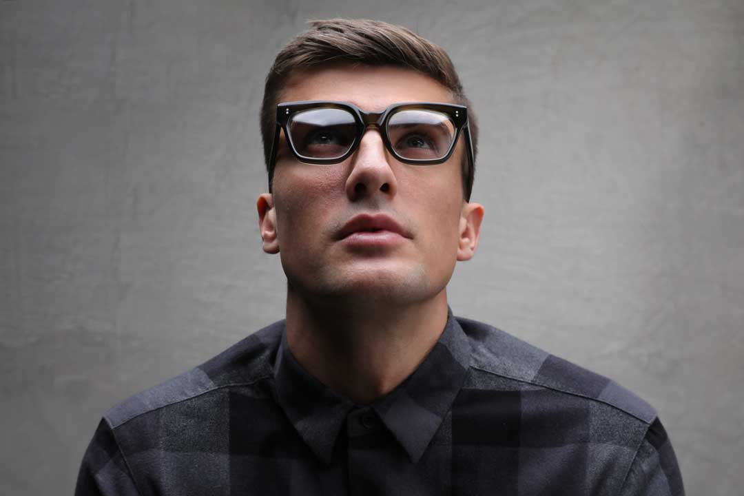 Man wearing small square glasses frame looking upwards