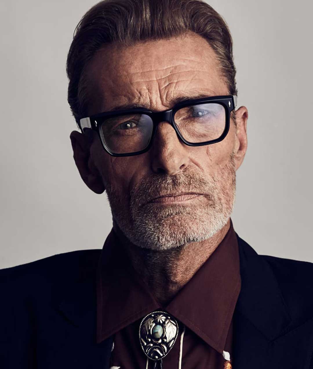 Mature gentleman wearing thick rimmed black eyeglasses frame