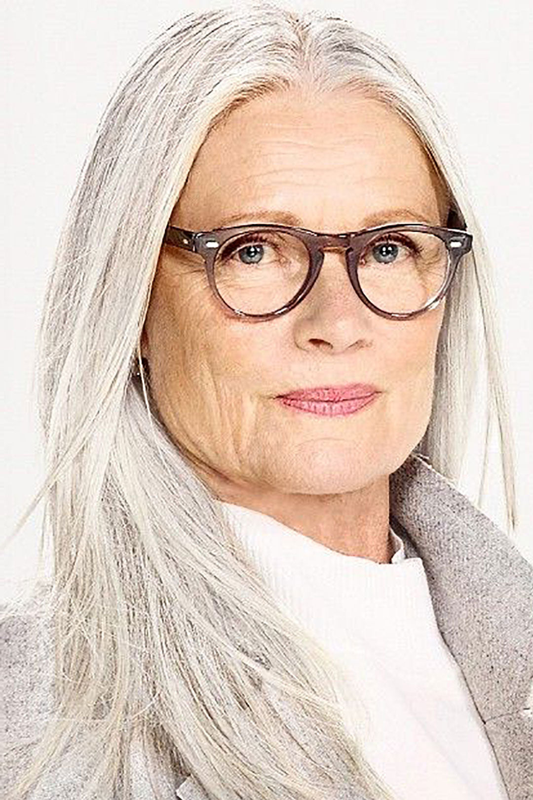 Mature lady in round spectacles with long grey hair