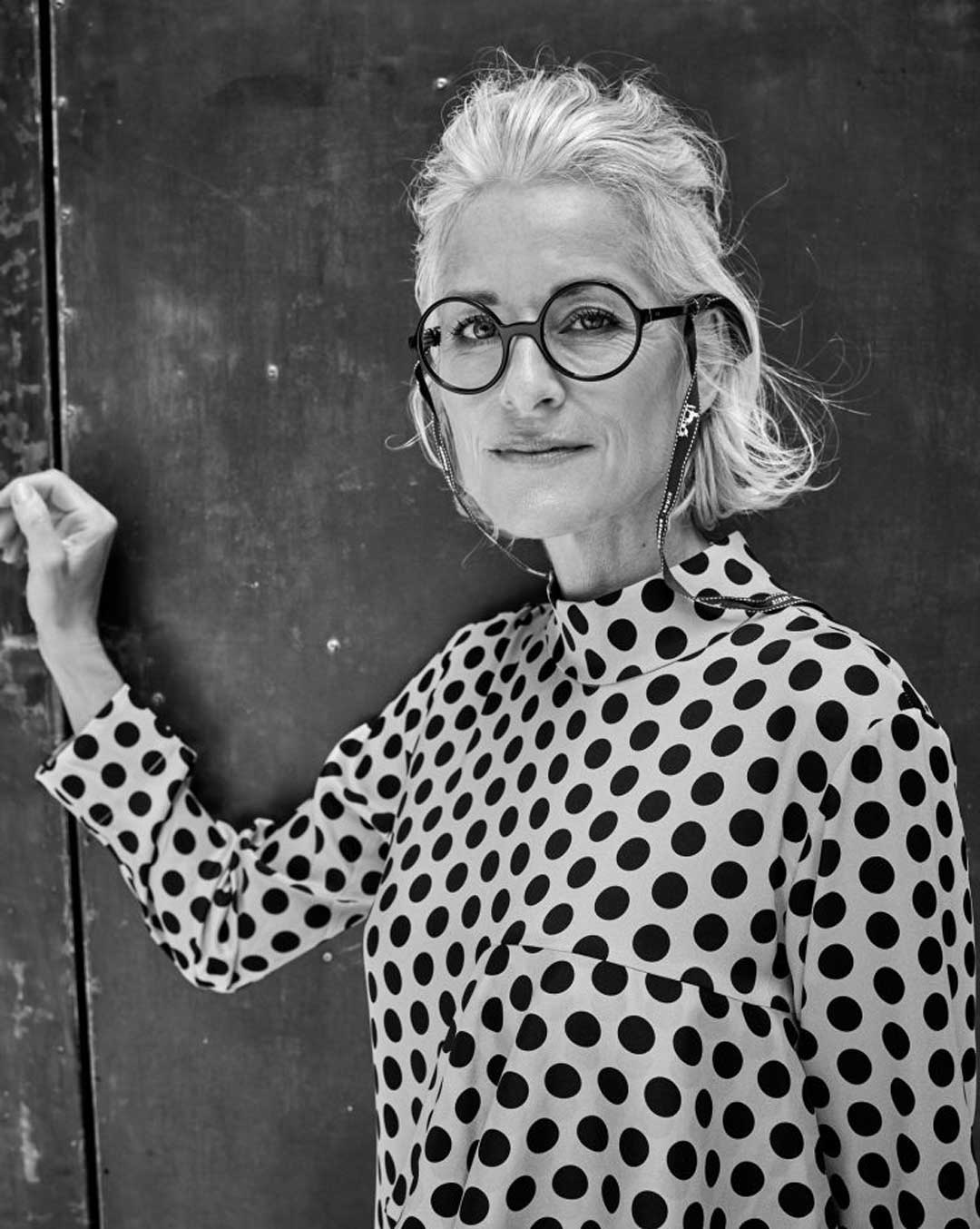 Mature-lady-wearing-polka-dot-blouse-and-round-black-eyeglasses-frame-smiling