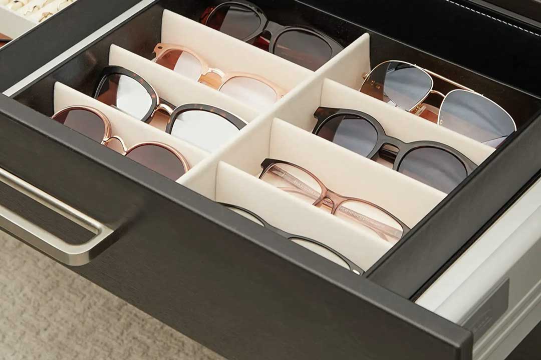 Numerous sunglasses frames inside an organised drawer tray