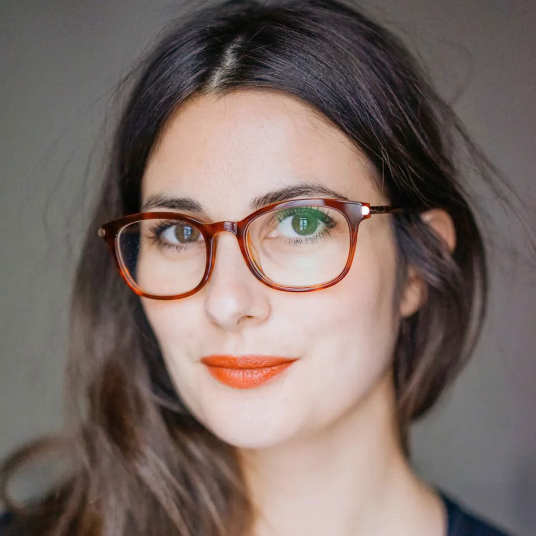 Portrait of pretty brunette wearing rounded rectangular eyeglass frame