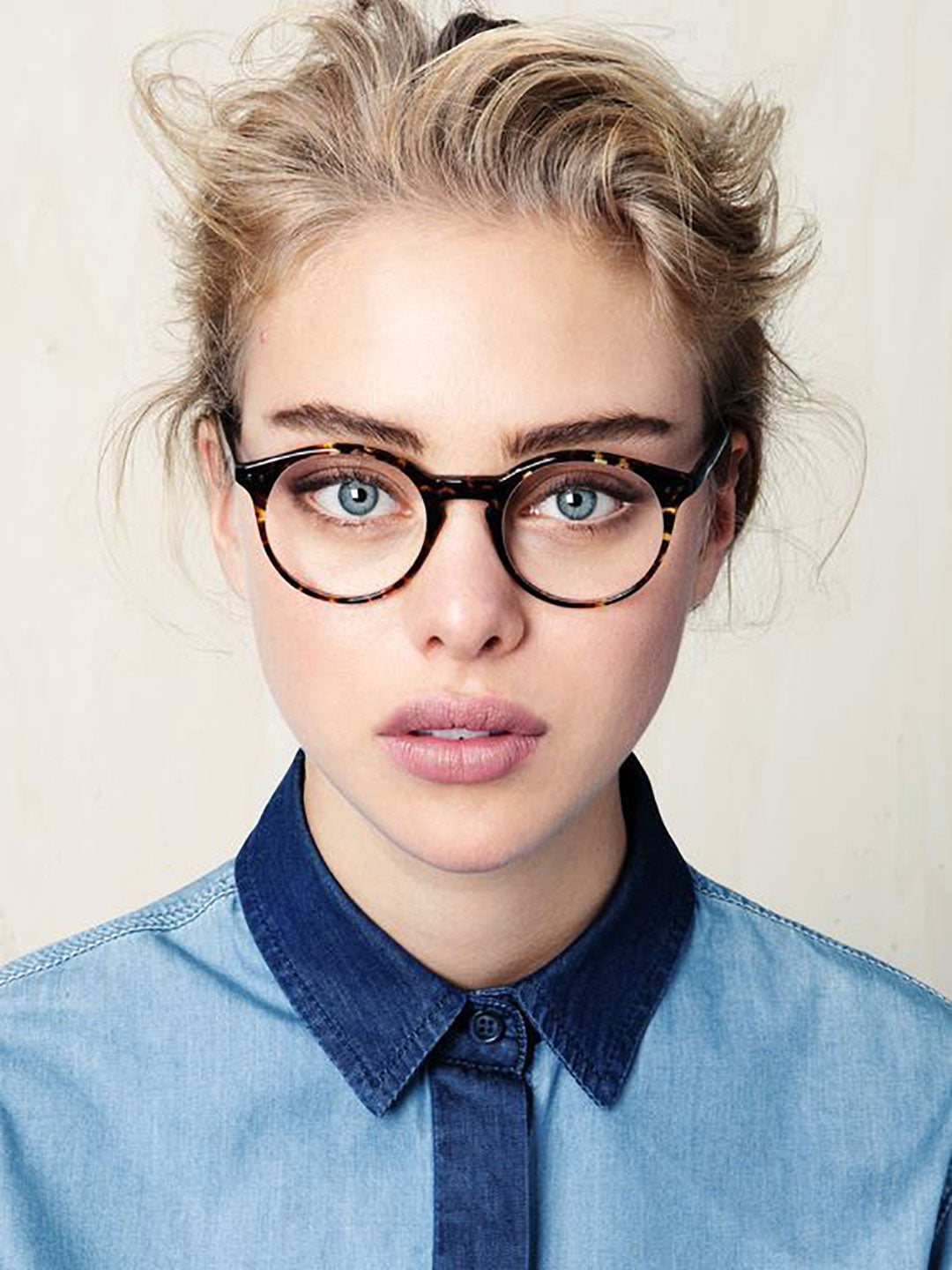 Portrait of young blonde lady wearing round tortoise shell eyeglasses