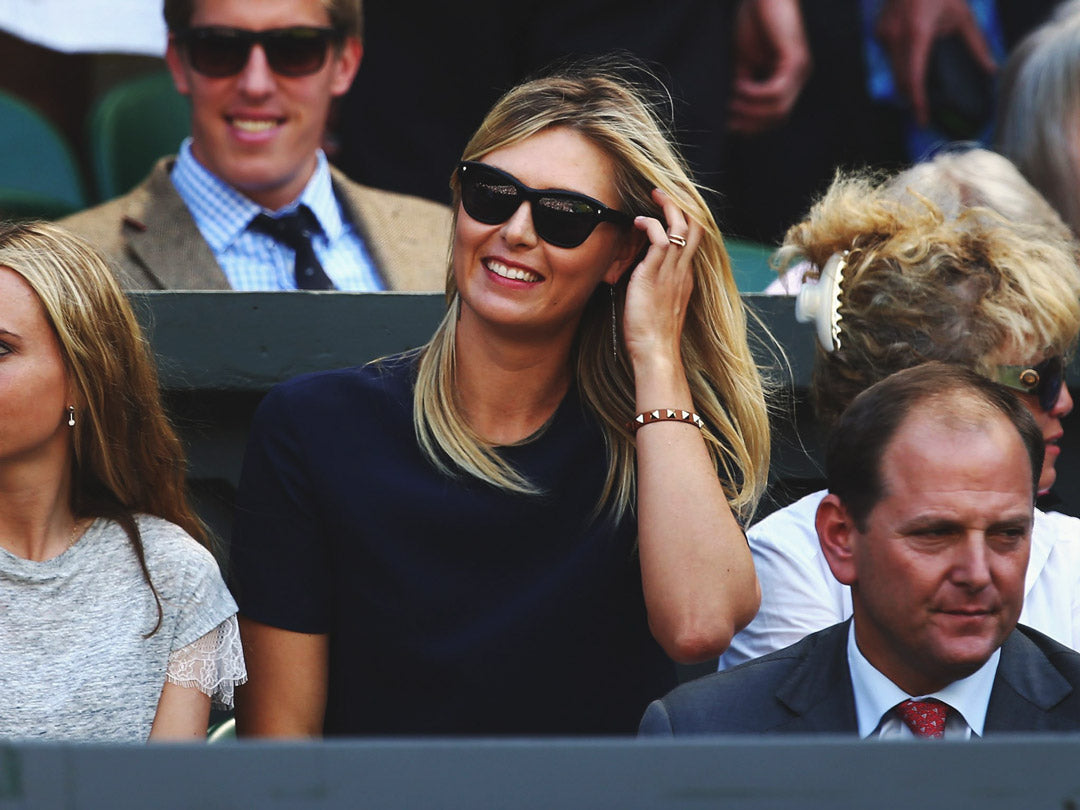 Professional tennis player Maria Sharapova in the crowd at Wimbledon smiling wearing square black sunglasses