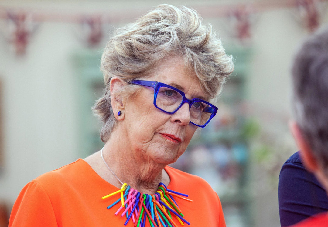 Prue Leith looking stern in her bright blue spectacle frame and orange blouse in the Great British Bake off tent