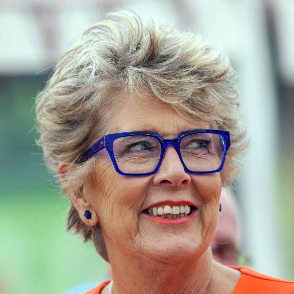 Prue Leith wearing thick blue glasses frame smiling