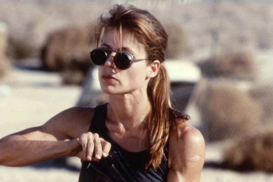 Sarah Connor in Terminator 2 wearing round Matsuda 2809 wire sunglasses holding a gun