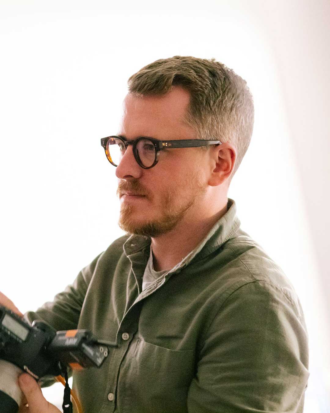 Side view of male photographer wearing thick round spectacle frame