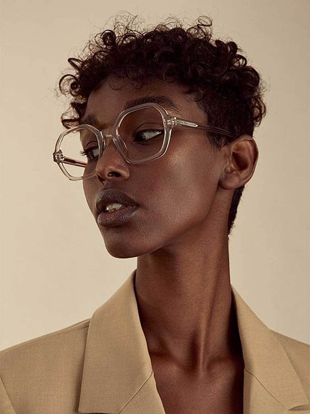 Side view of woman wearing nude crystal spectacles and cream blazer looking away