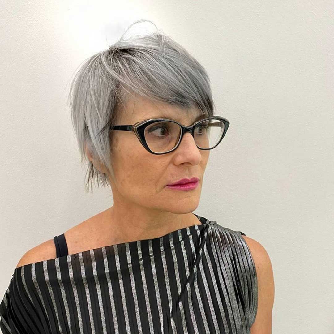 Side view of woman with straight grey pixie haircut wearing black cat eye glasses frame