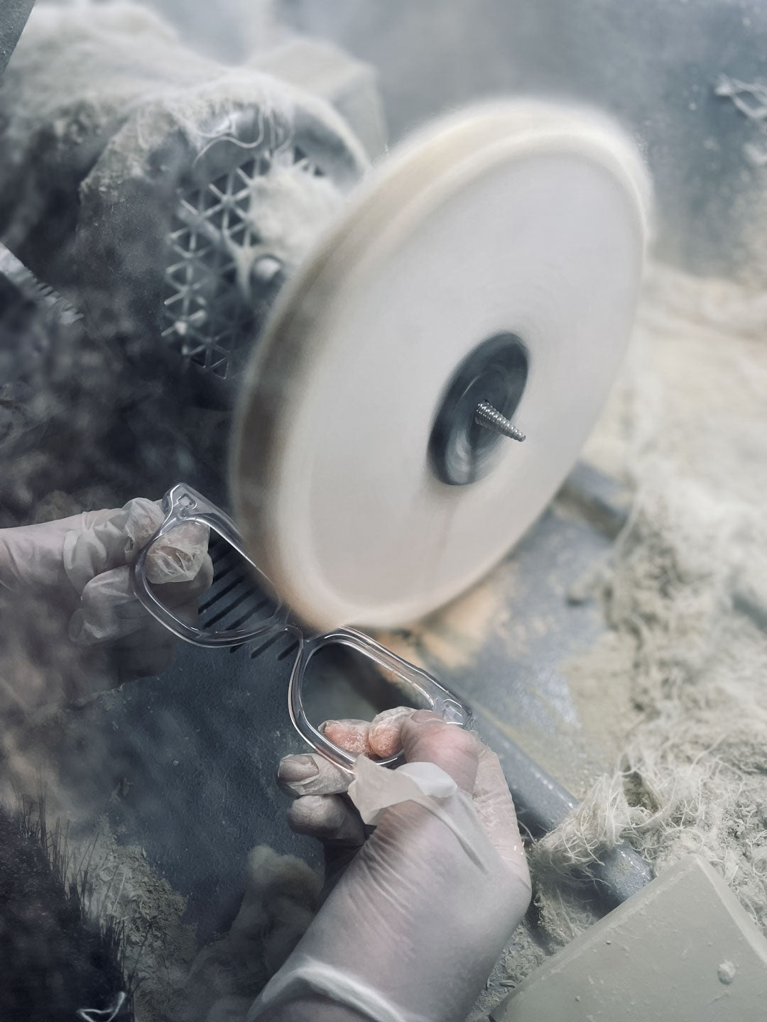 Skilled worker wheel polishing a crystal clear sunglasses frame front