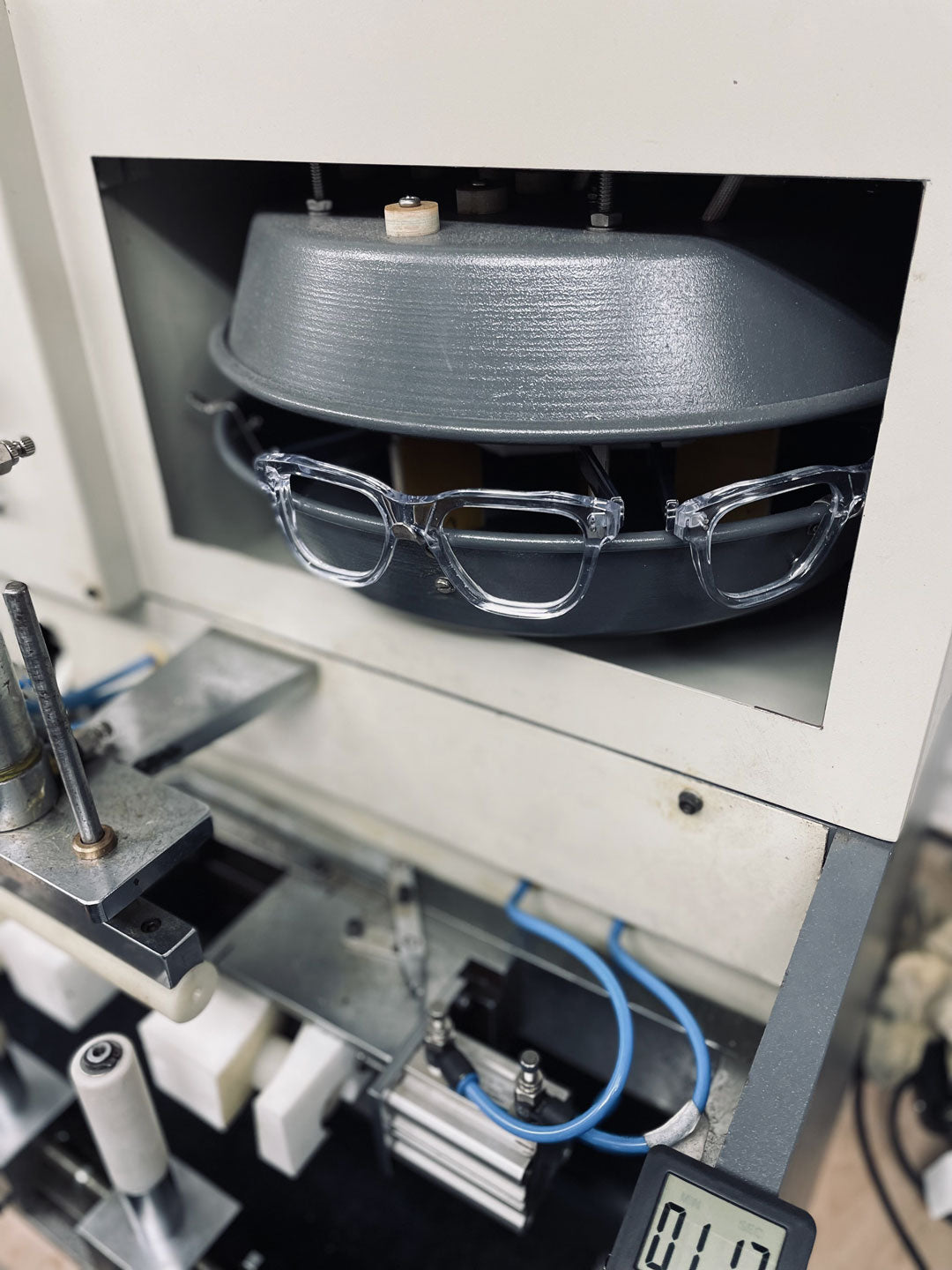 Sunglasses frames being heater inside grey rotational oven machine