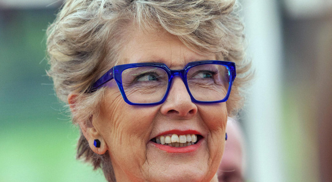 TV presenter Prue Leith wears a rectangular blue spectacle frame with blue earrings inside the Great British Bake Off tent