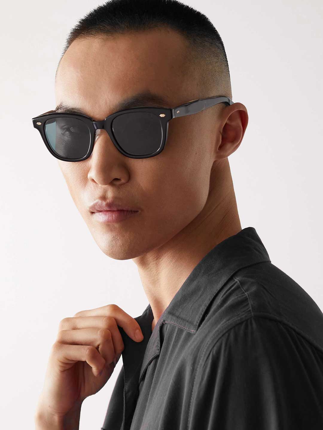 Three quarter view of Asian man wearing black rectangular sunglasses