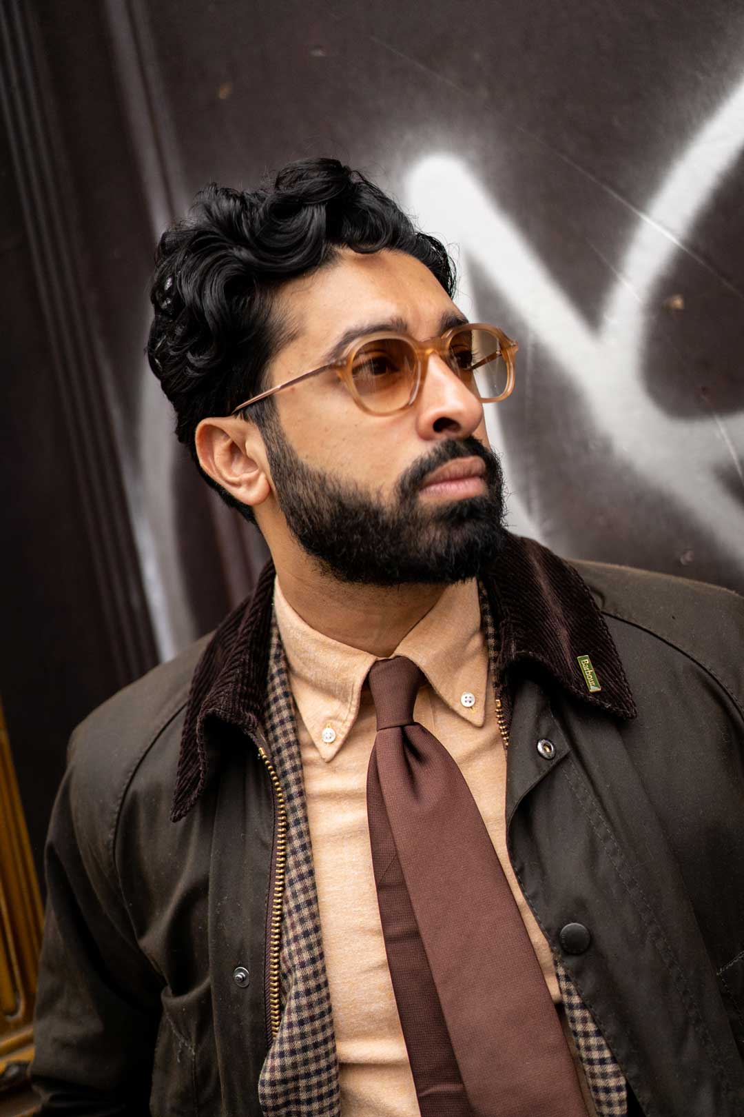 Three quarter view of bearded man wearing vintage pilot shape eyglasses with brown tinted lenses